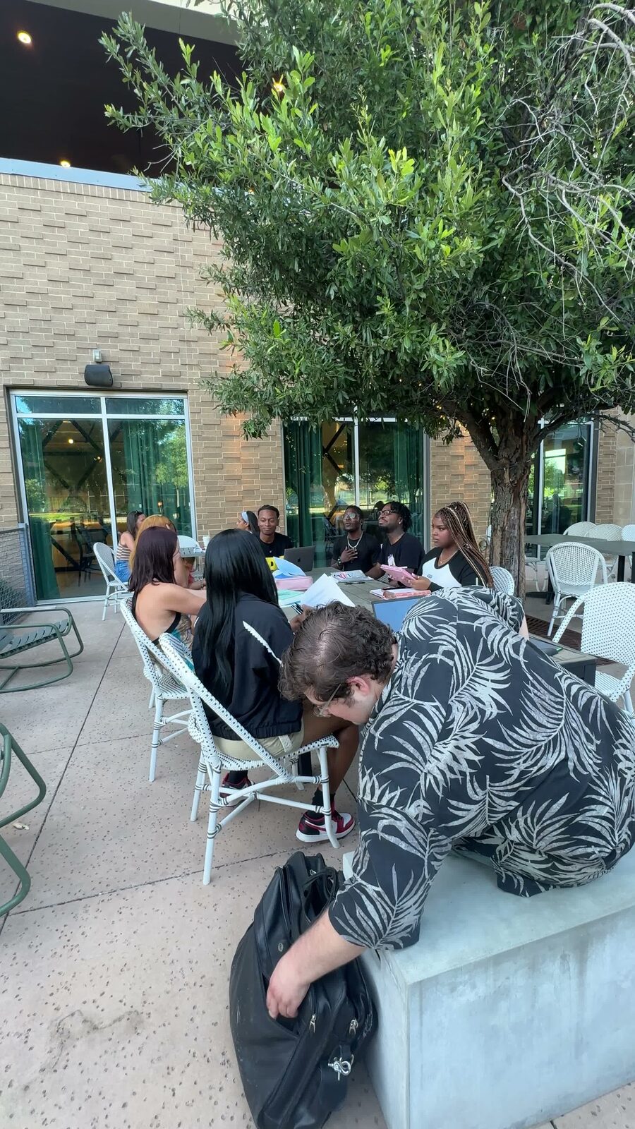 An open-air Club Polis study session around a patio table in the evening